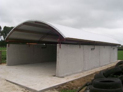 A large building with a white roof is surrounded by tires.