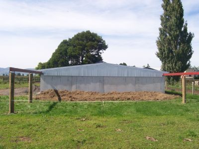 A large concrete structure is in the middle of a grassy field