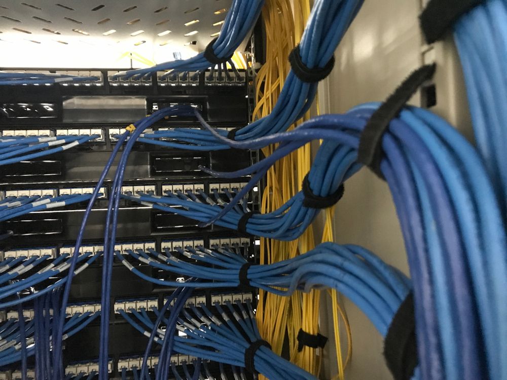 A Bunch of Blue and Yellow Wires Are Hanging From a Rack — Lismore Computer Solutions in Kyogle, NSW