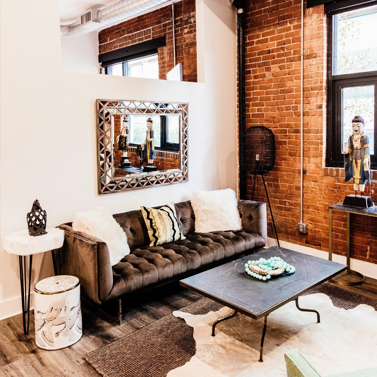 A living room with a couch , coffee table , and mirror.