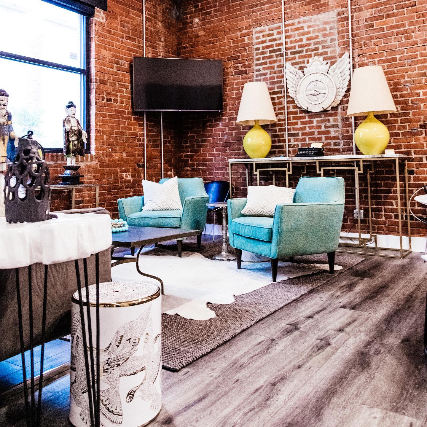 A living room filled with furniture and a brick wall