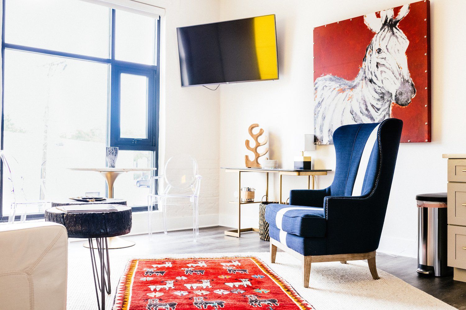 There is a painting of a zebra on the wall above the chair in the living room.