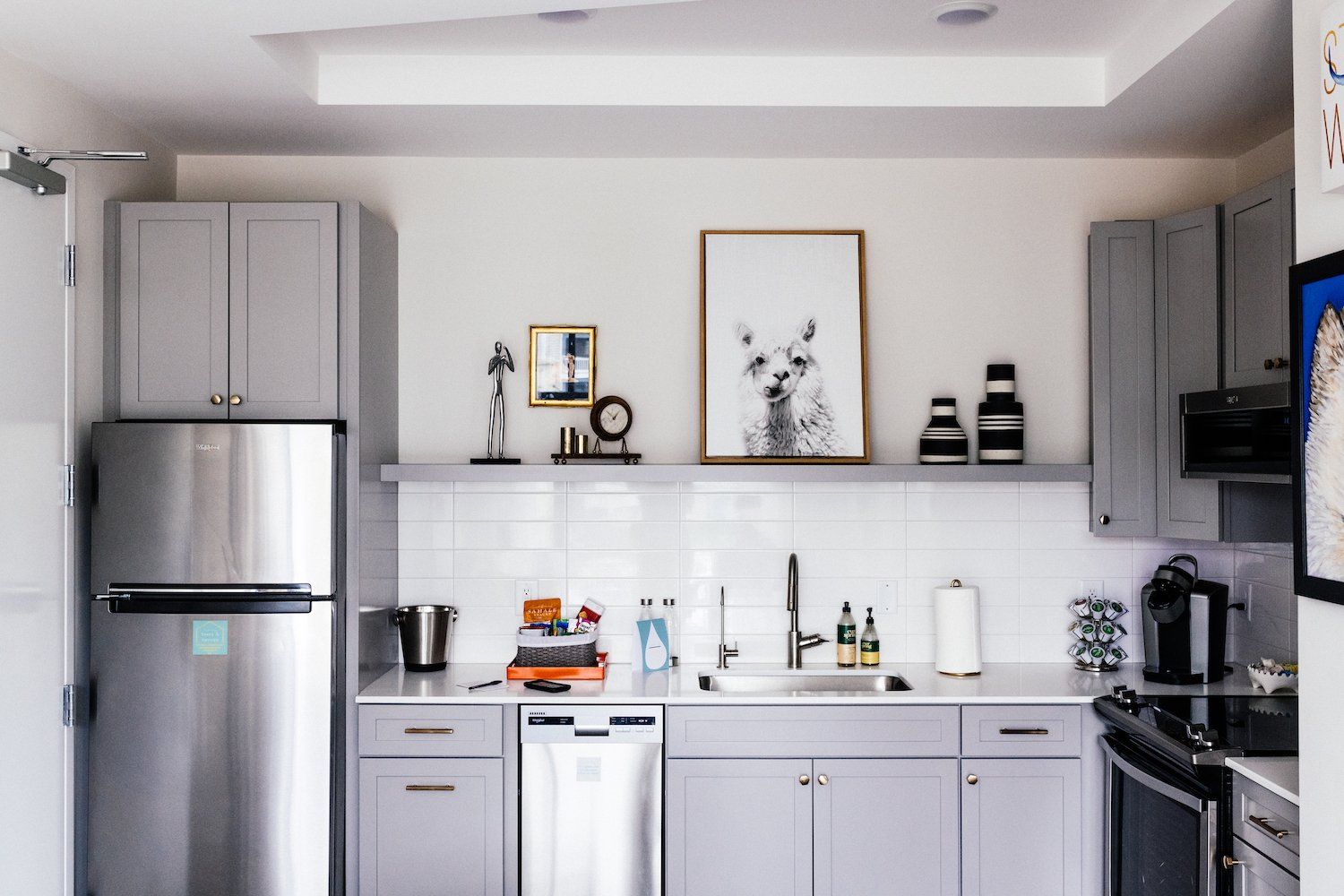 A kitchen with stainless steel appliances and gray cabinets