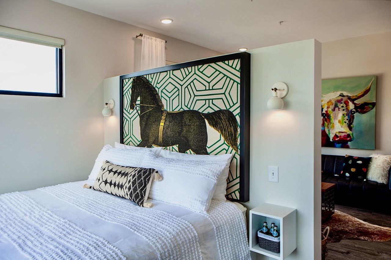 There is a painting of a horse on the headboard of the bed.