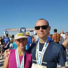 A man and a woman are posing for a picture at a marathon.