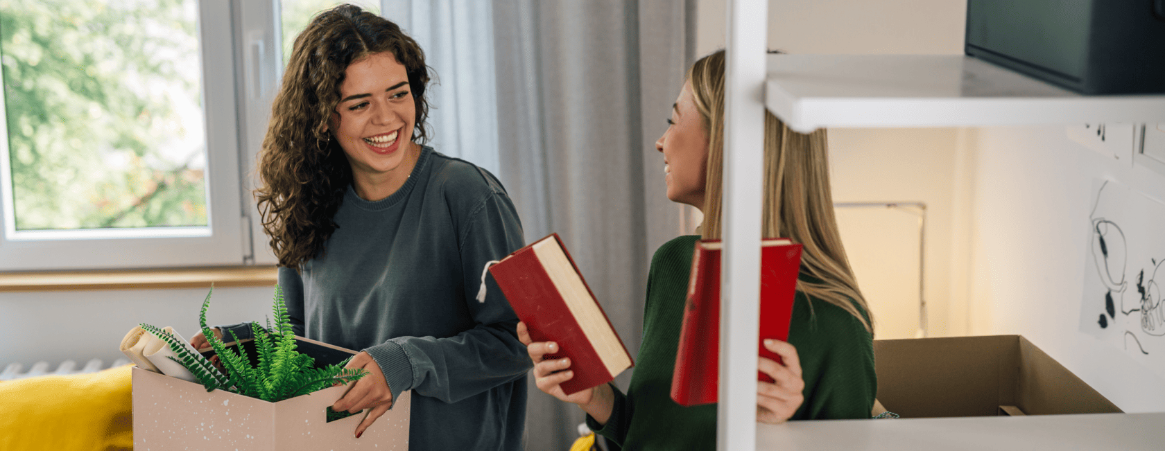 Duas meninas conversando e arrumando suas coisas em seu novo apartamento