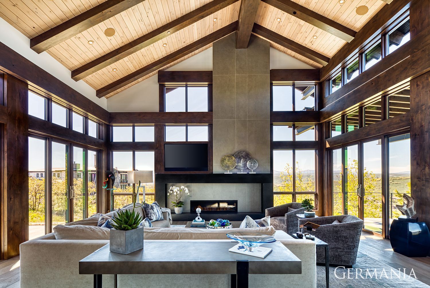 A living room with a lot of windows and a fireplace