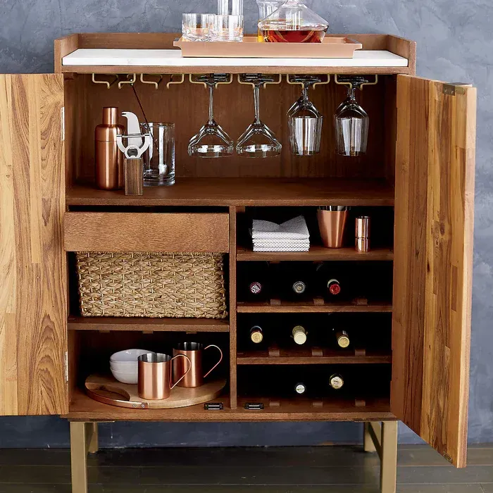 A wooden cabinet filled with wine bottles and glasses