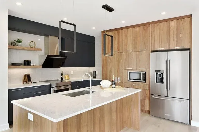 A kitchen with stainless steel appliances , wooden cabinets , and a large island.