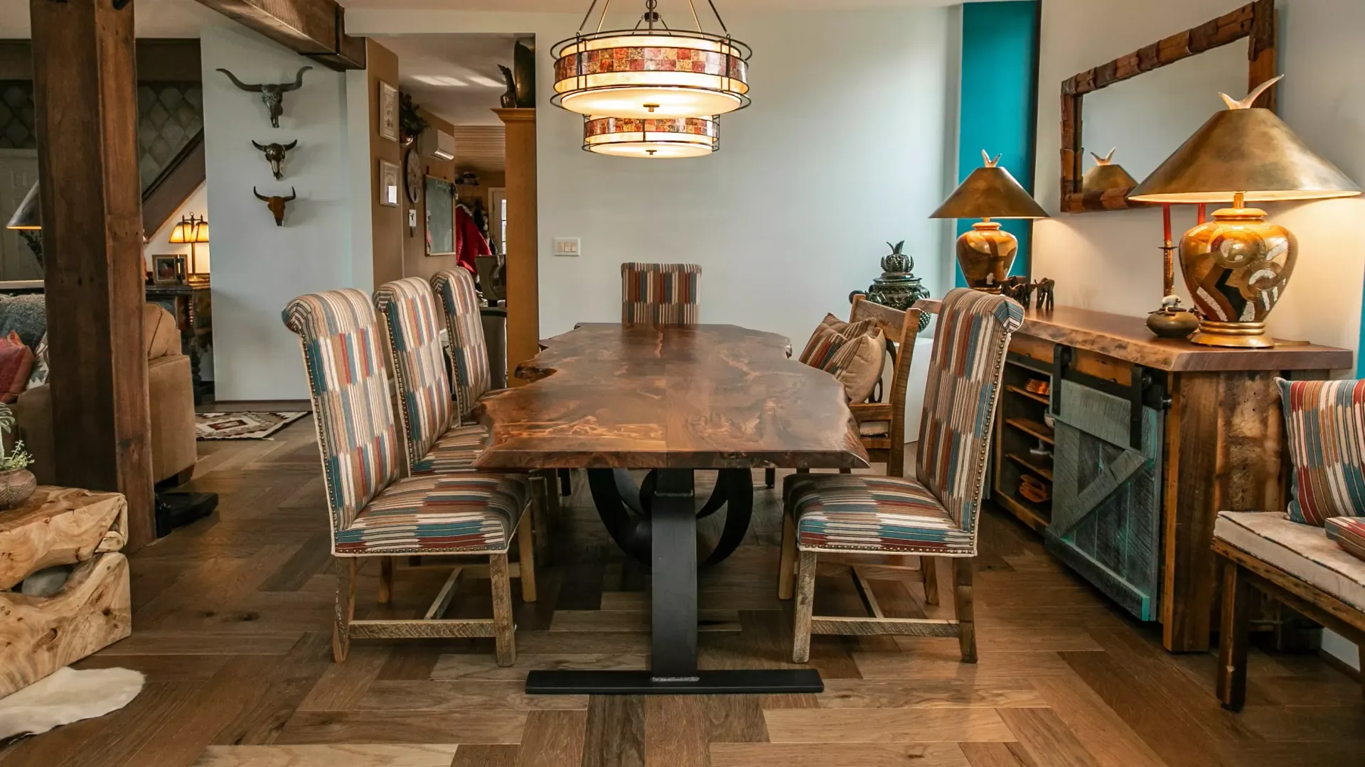 A dining room with a long wooden table and chairs.