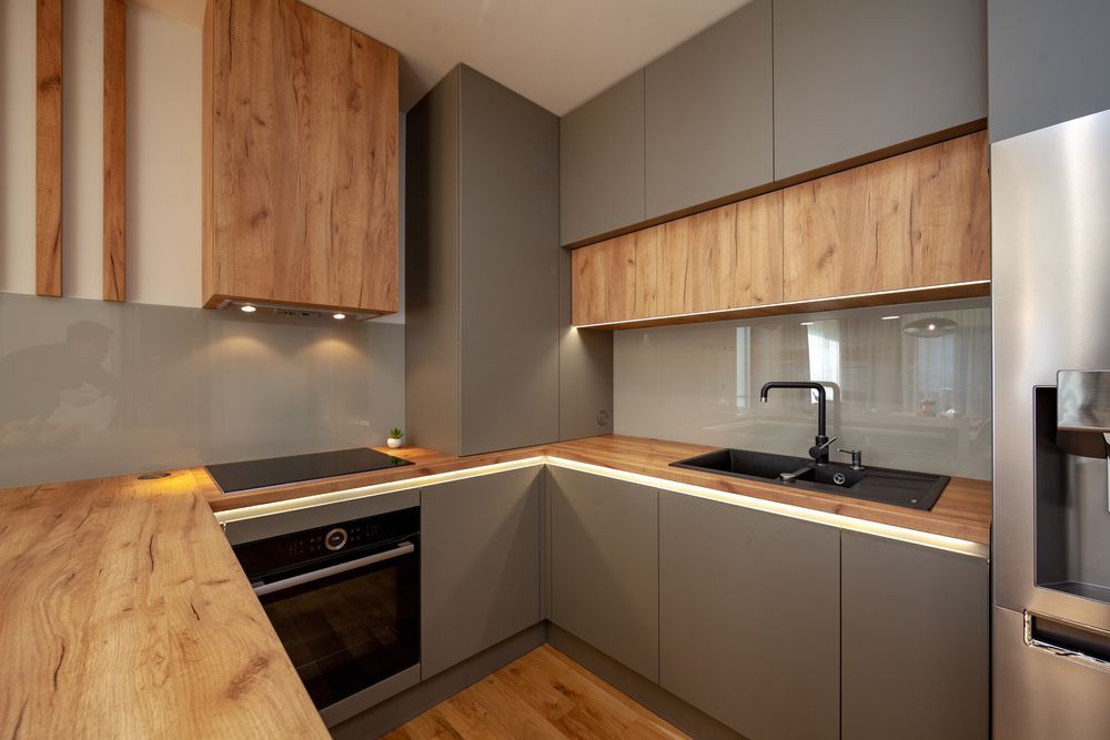 A kitchen with wooden cabinets , stainless steel appliances , a sink , and a refrigerator.