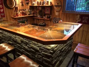 A bar with a stone wall and wooden stools