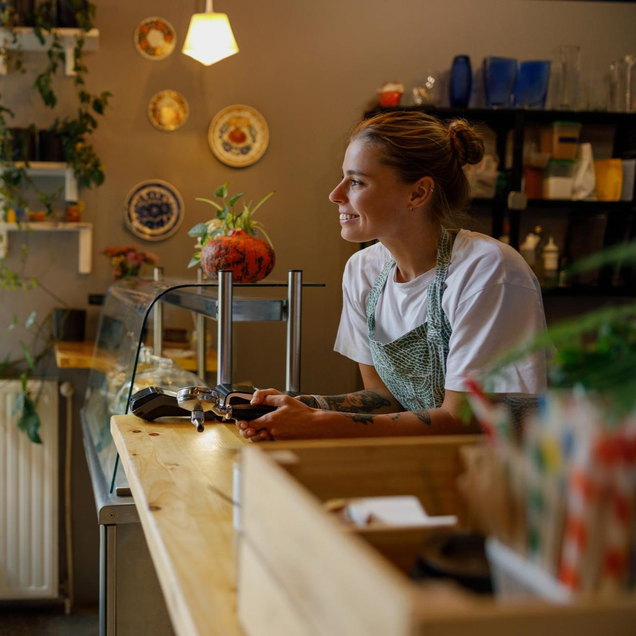 A woman is carrying a little girl on her shoulders in a field at sunset.