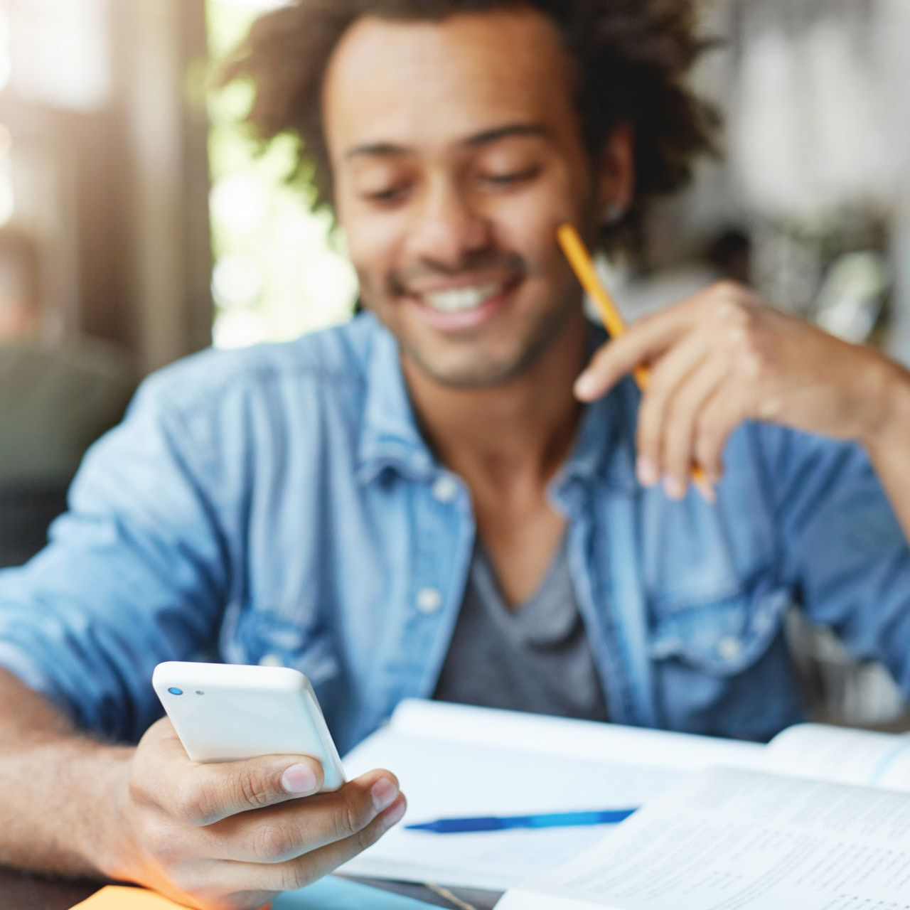 A woman is carrying a little girl on her shoulders in a field at sunset.