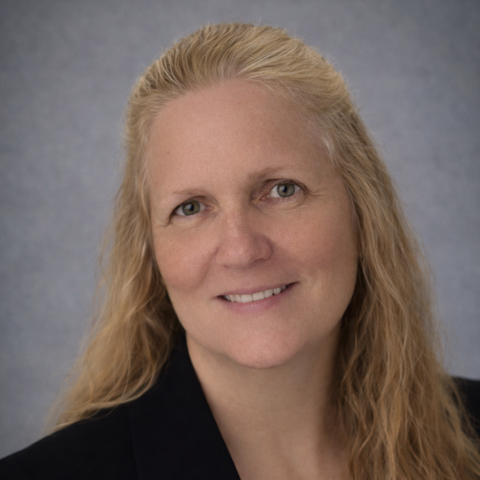 A man in a suit and tie is smiling in front of a window
