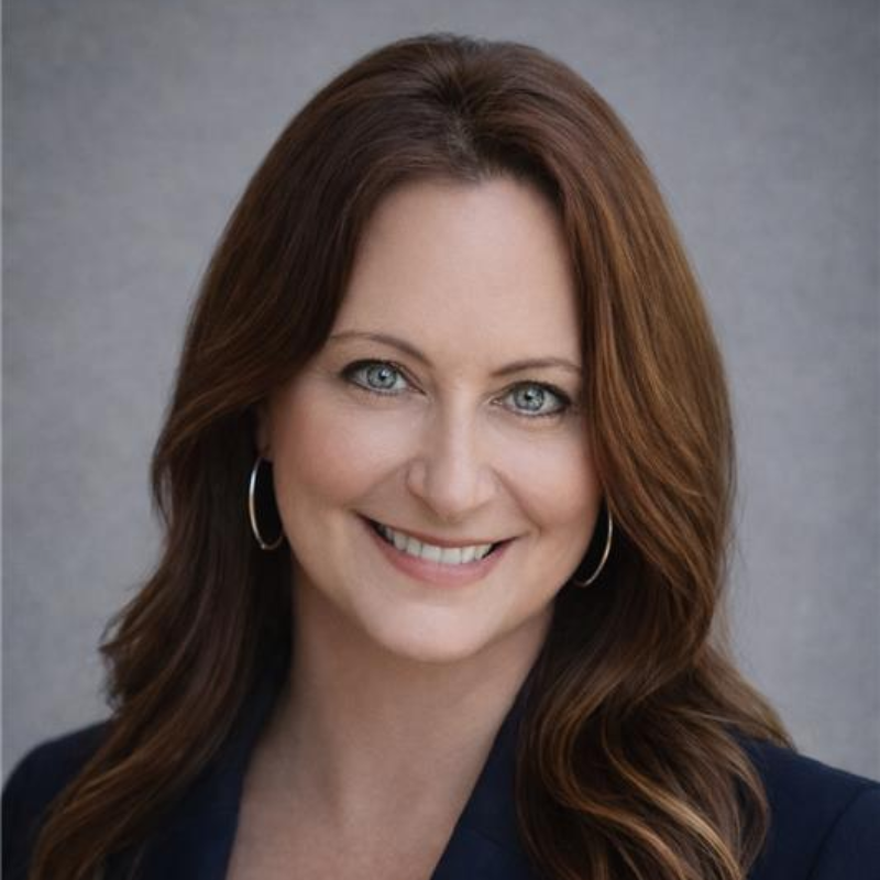A man in a suit and tie is smiling in front of a window