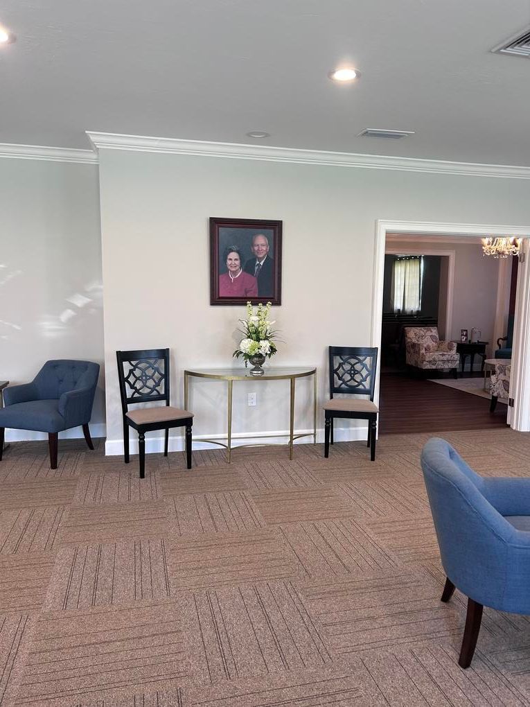 The front door of a house with a porch and plants in front of it.