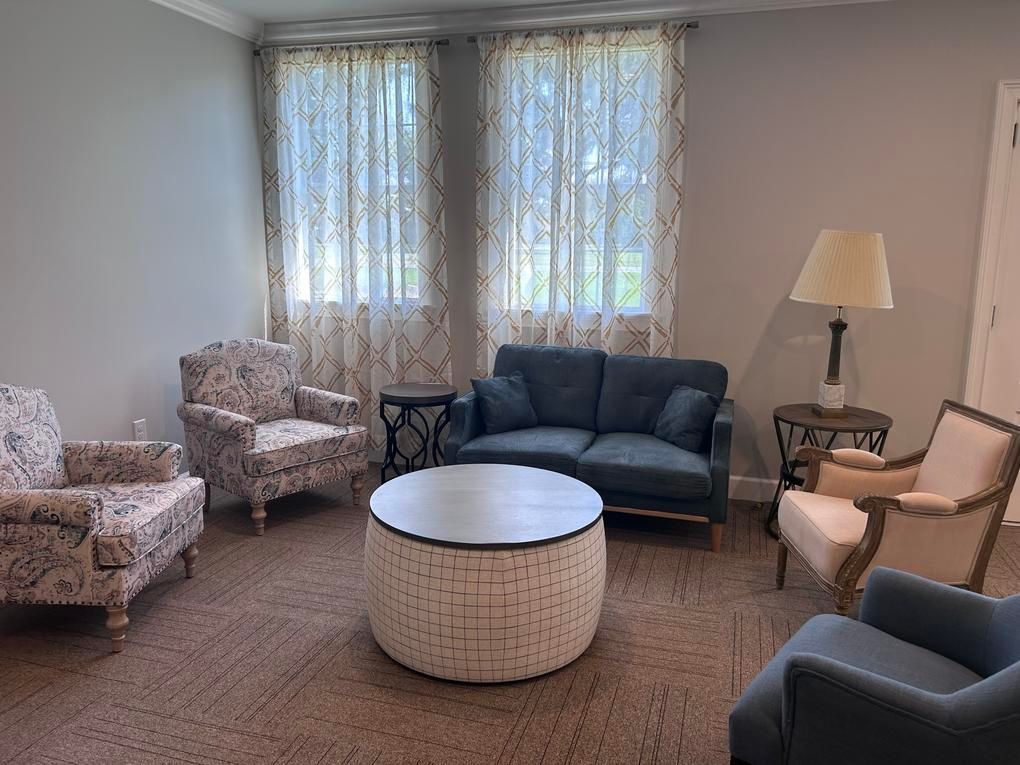 A living room with a couch , chairs and a table