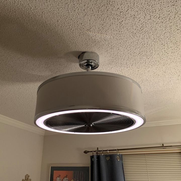 A ceiling fan is hanging from the ceiling in a room.
