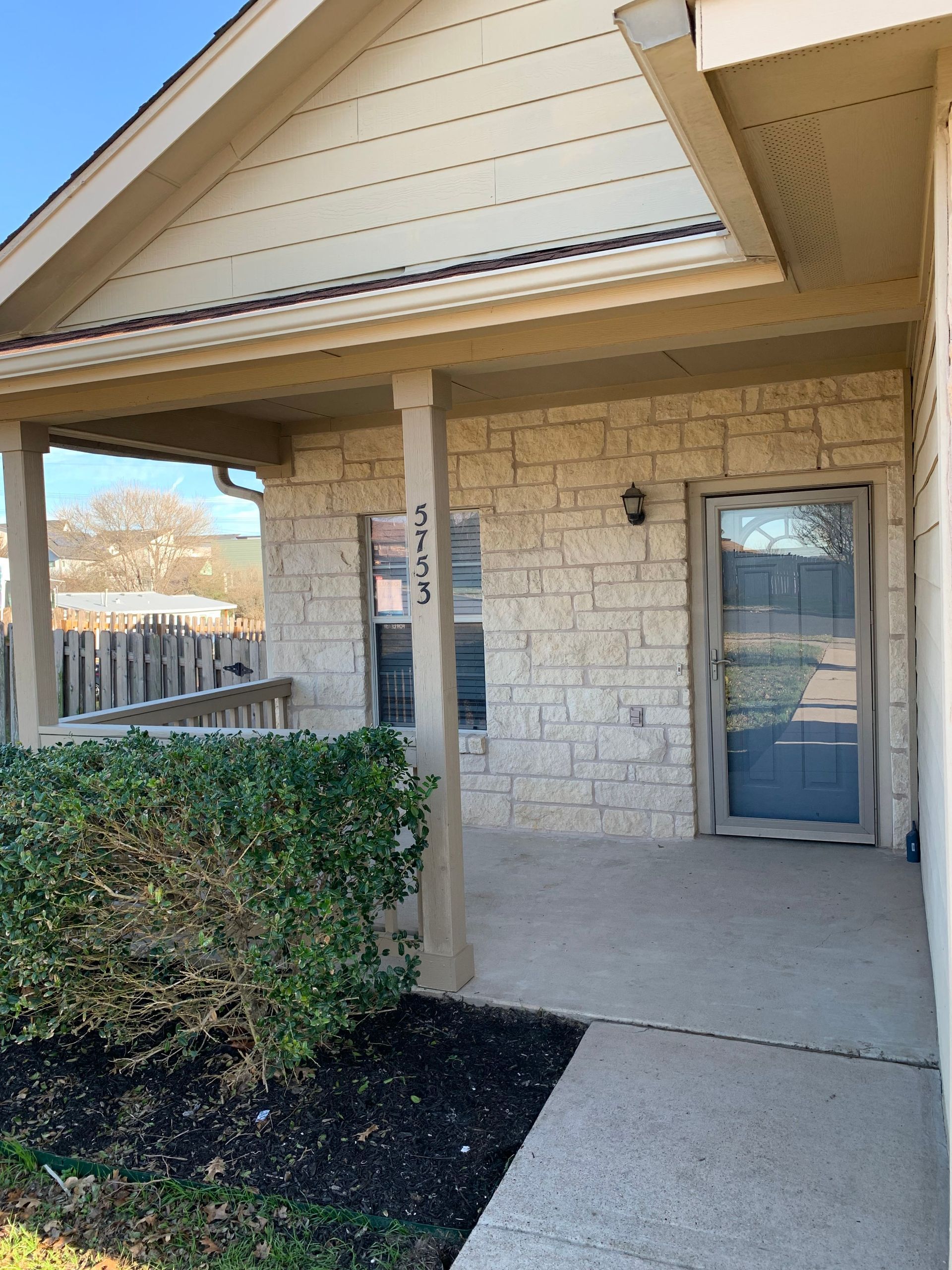 A brick house with a porch and a door