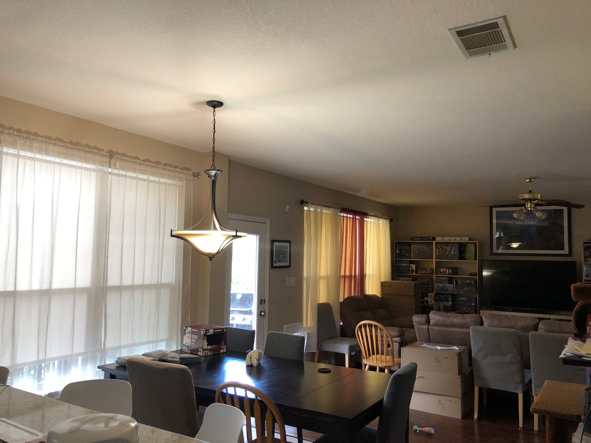 A living room with a table and chairs and a ceiling fan
