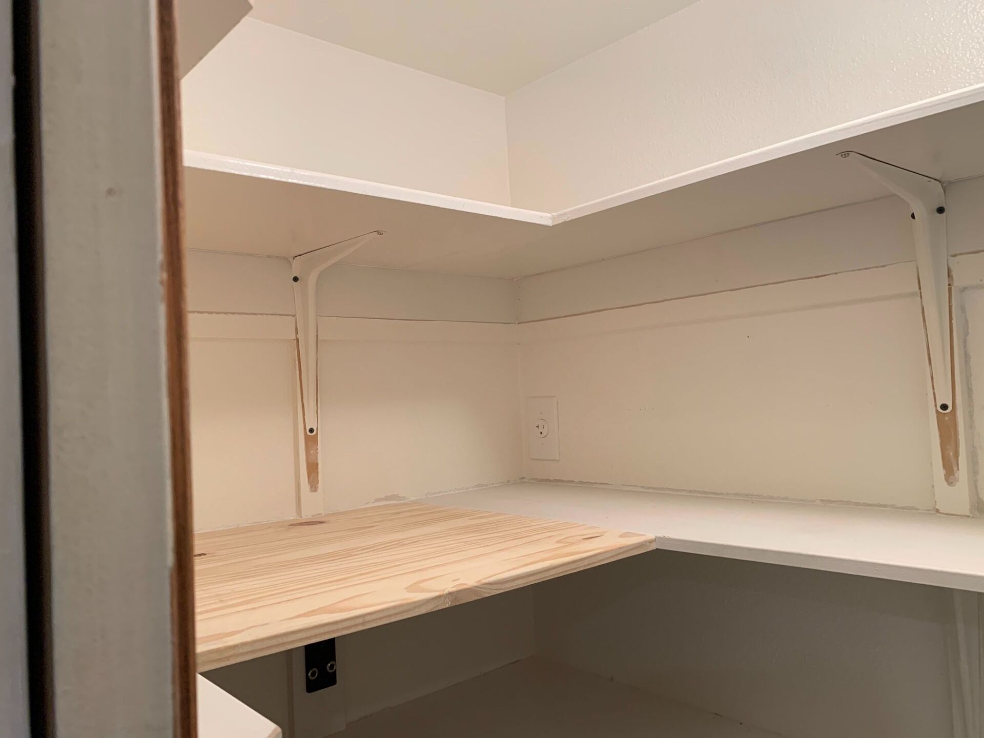 There is a wooden table in the corner of the room.