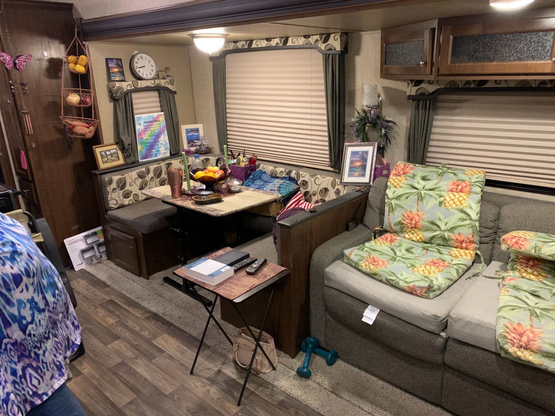 A living room in a rv with a couch , table and chairs.