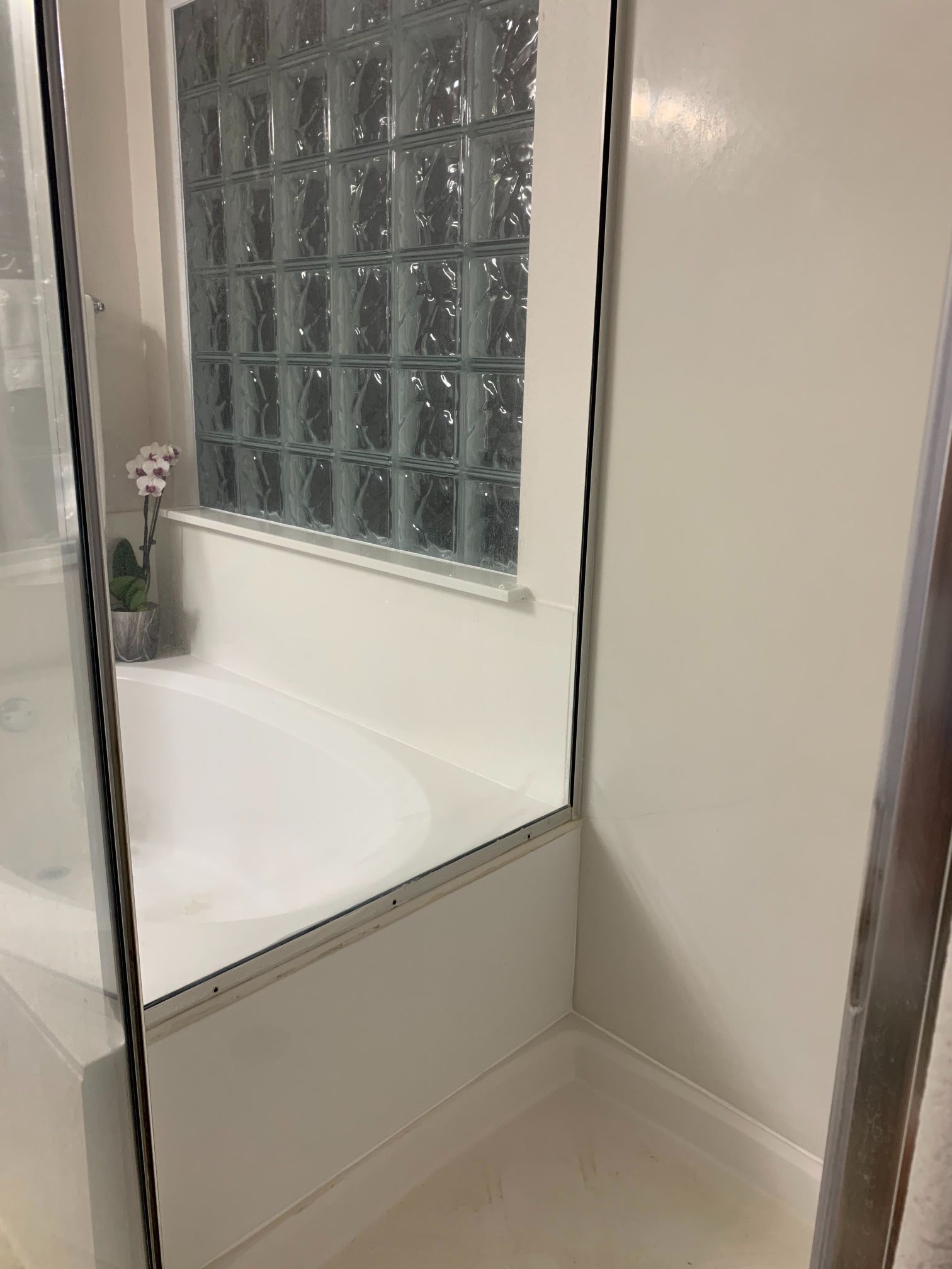 A bathroom with a bathtub and a large mirror.