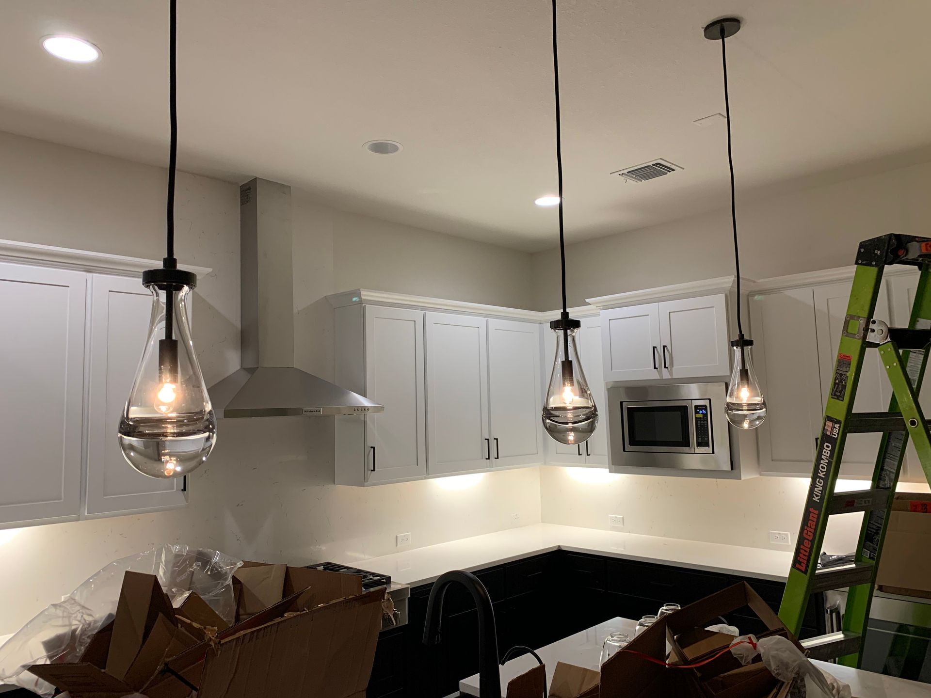 A kitchen with white cabinets and black counter tops is being remodeled.
