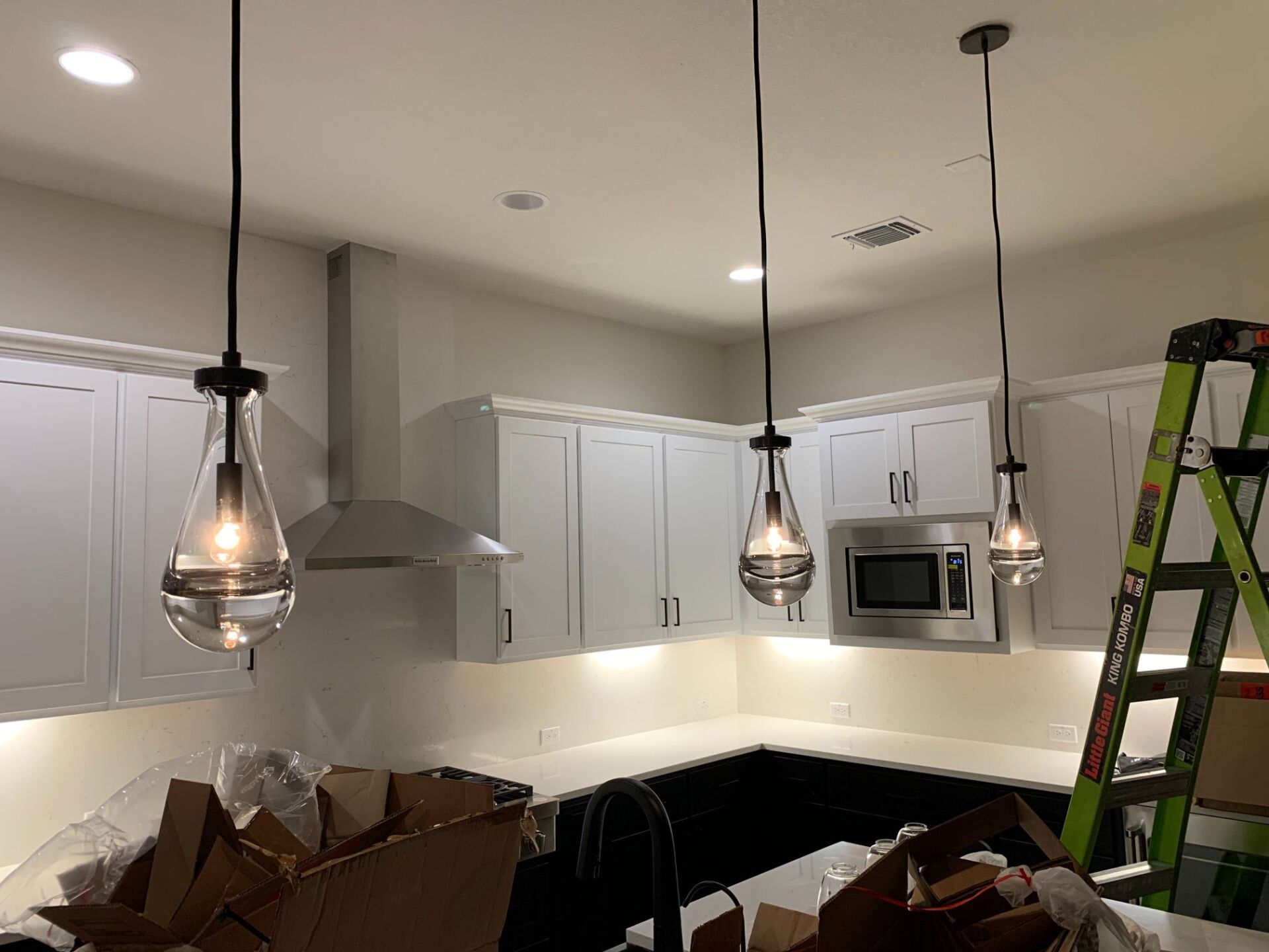 A kitchen with white cabinets and black counter tops is being remodeled.