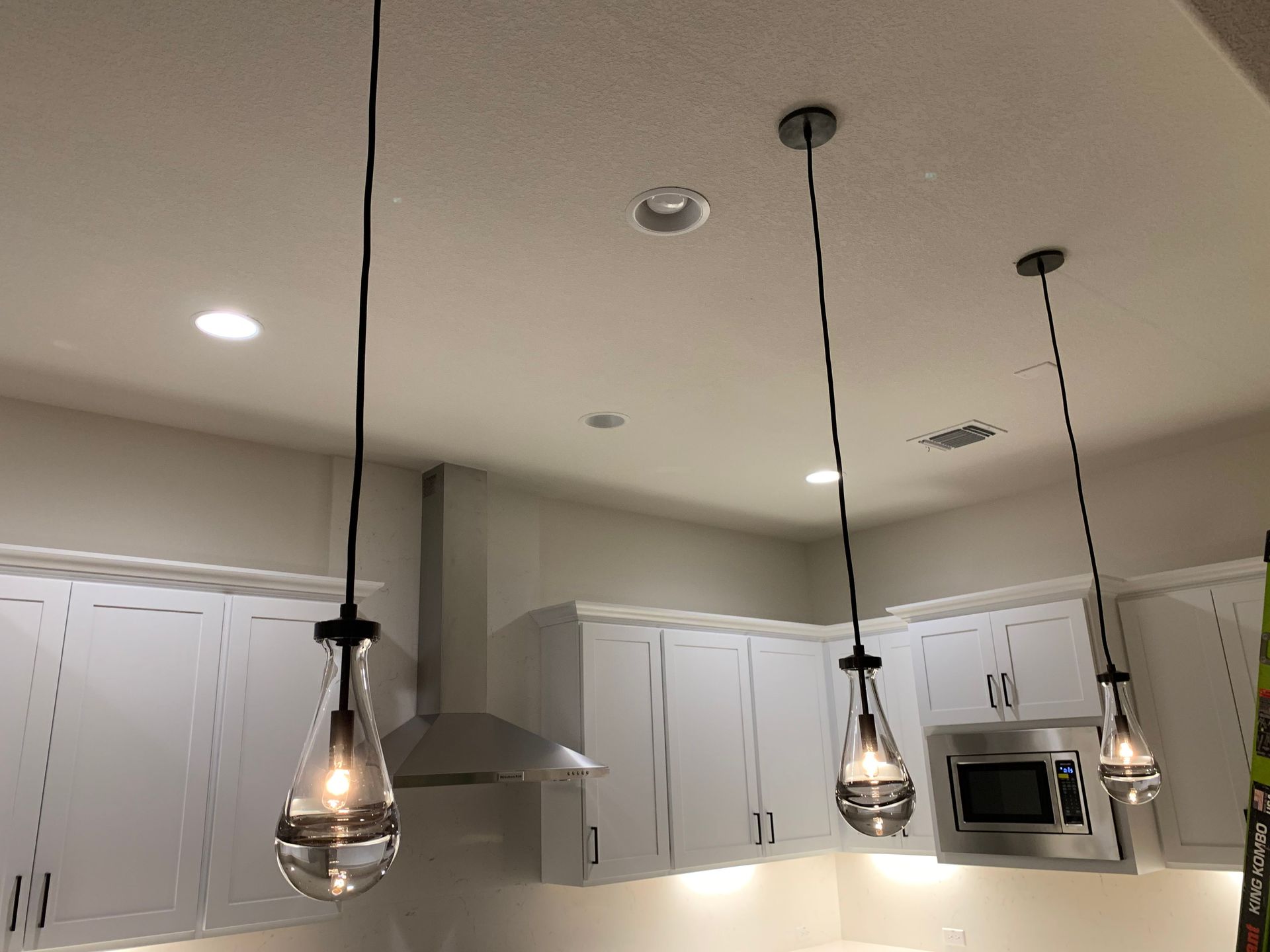Three pendant lights are hanging from the ceiling in a kitchen.
