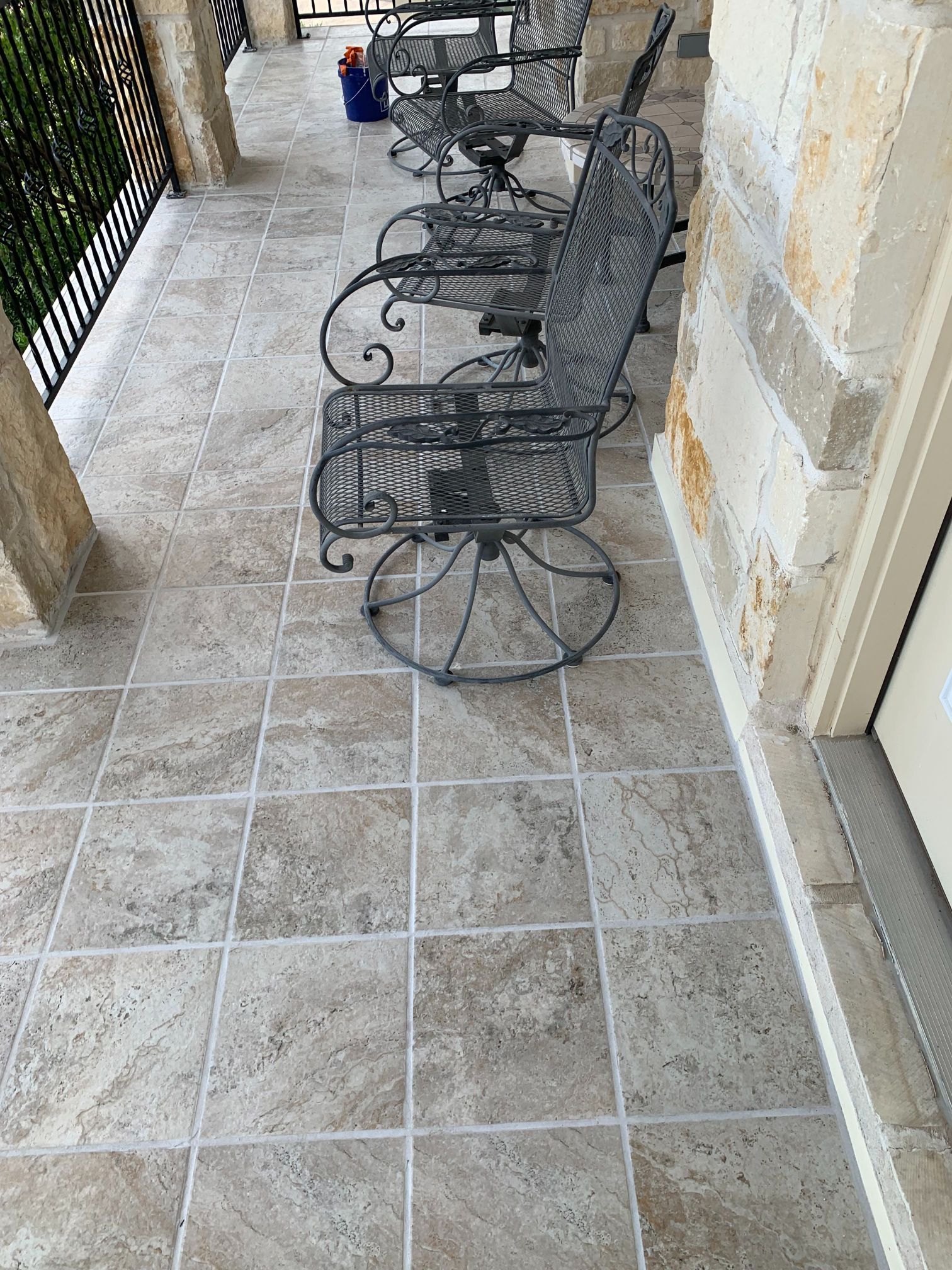A patio with a row of chairs and tables on it.