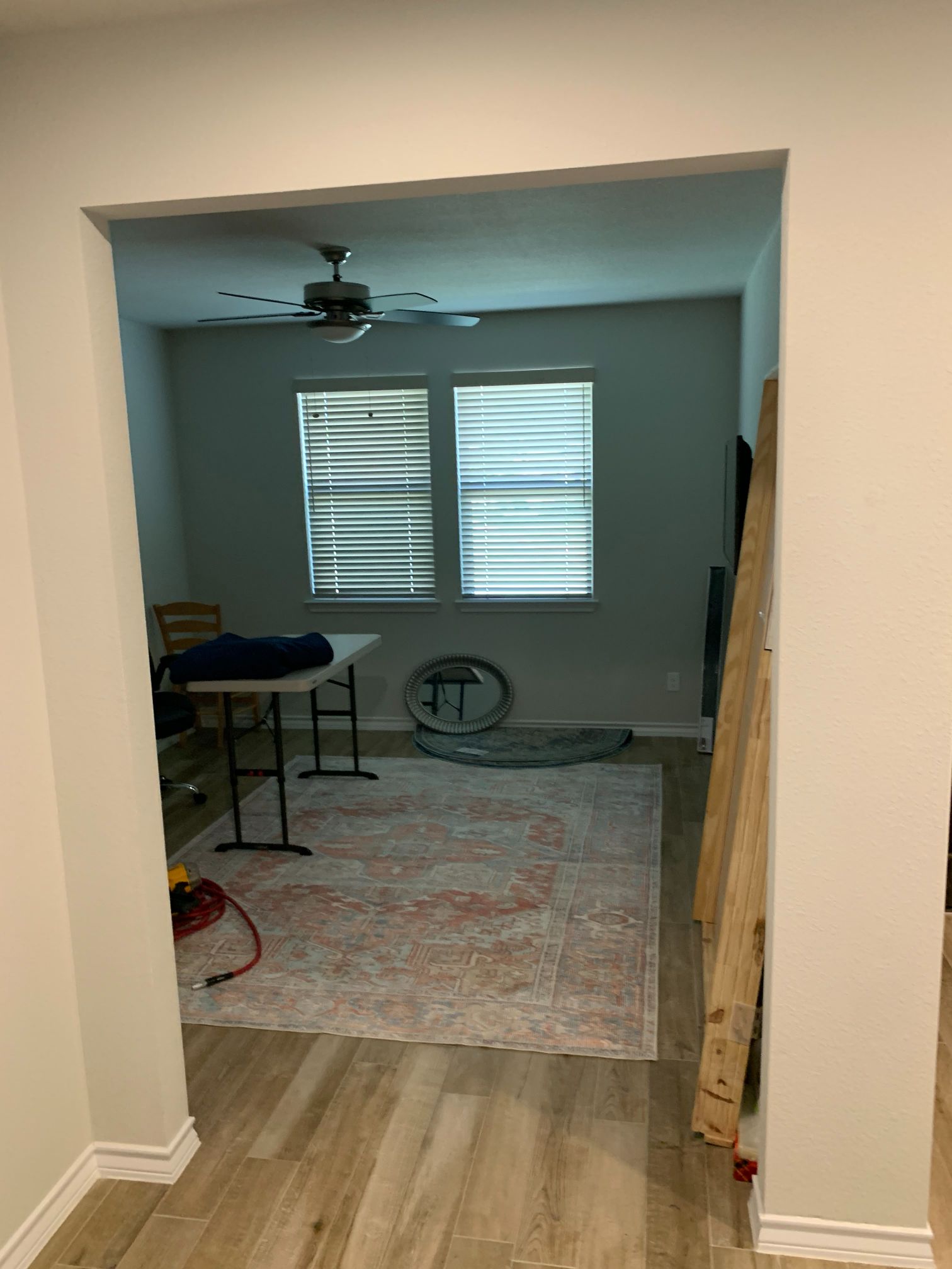 A room with a table and chairs in it and a ceiling fan.