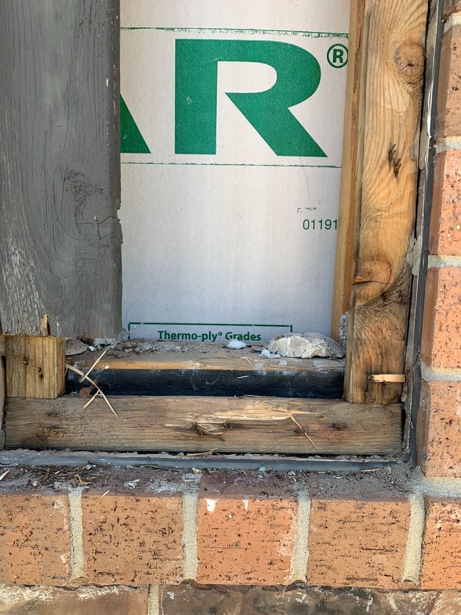 A box with the letter r on it is sitting on a brick wall.