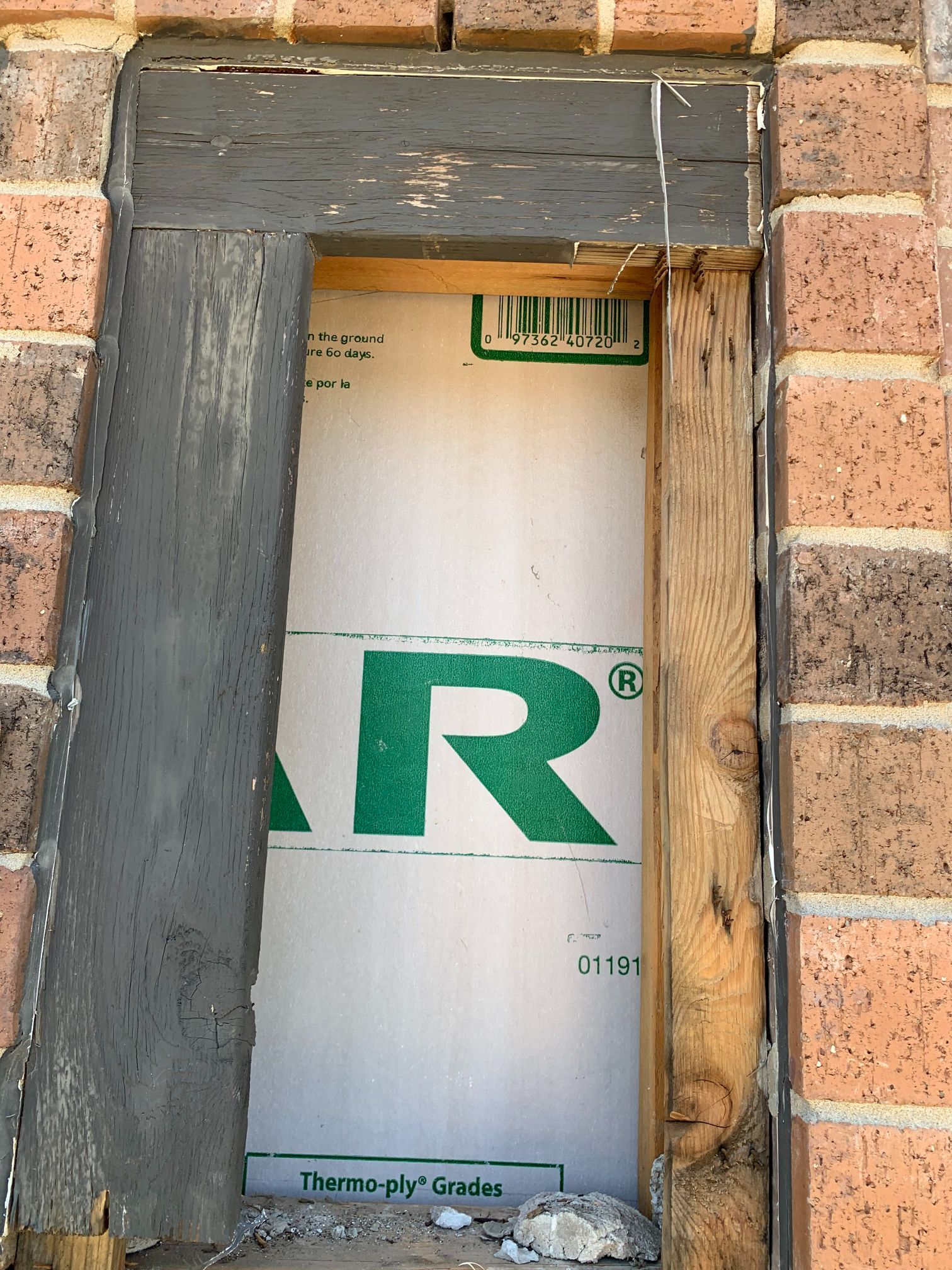 A window in a brick wall with a green r on it