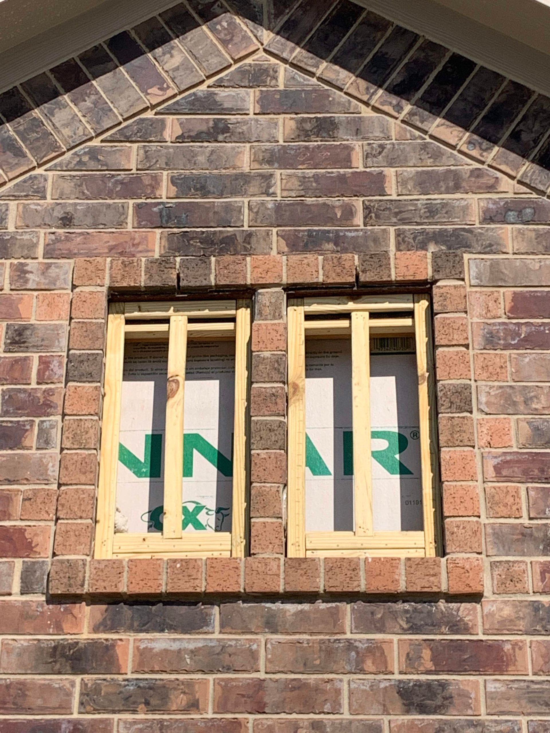 A window is being built into a brick wall.