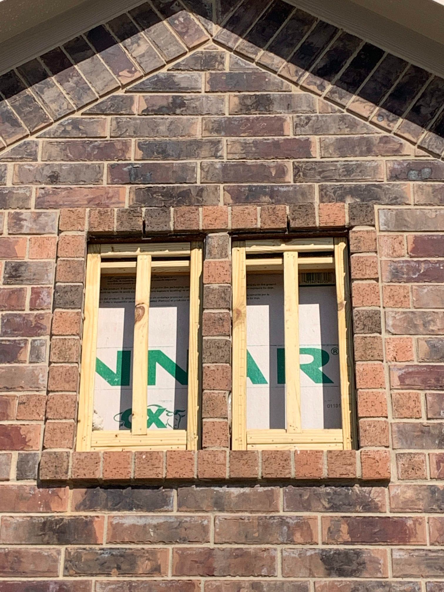 A window is being built into a brick wall.
