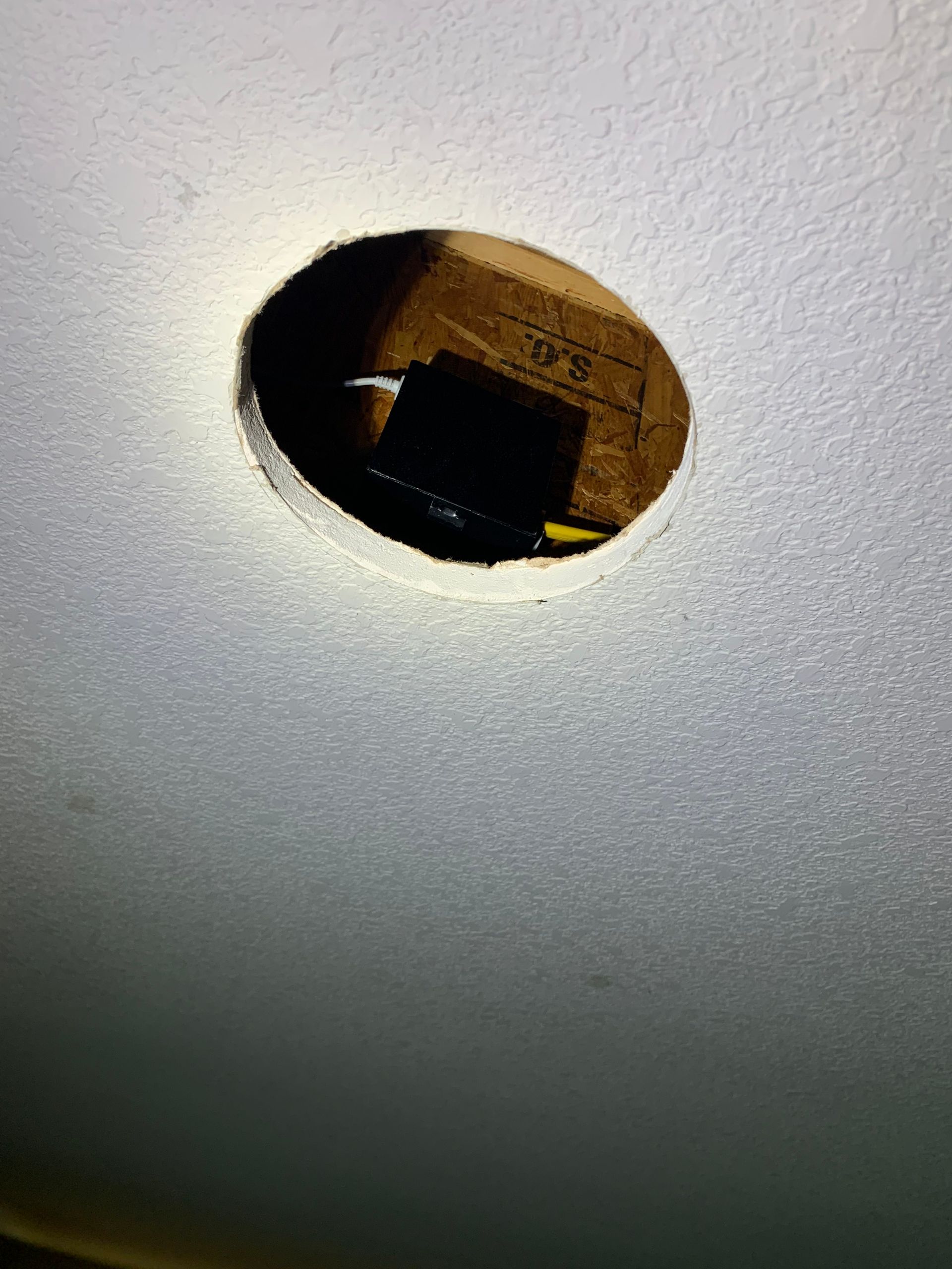 A close up of a hole in a wall with a light shining through it.