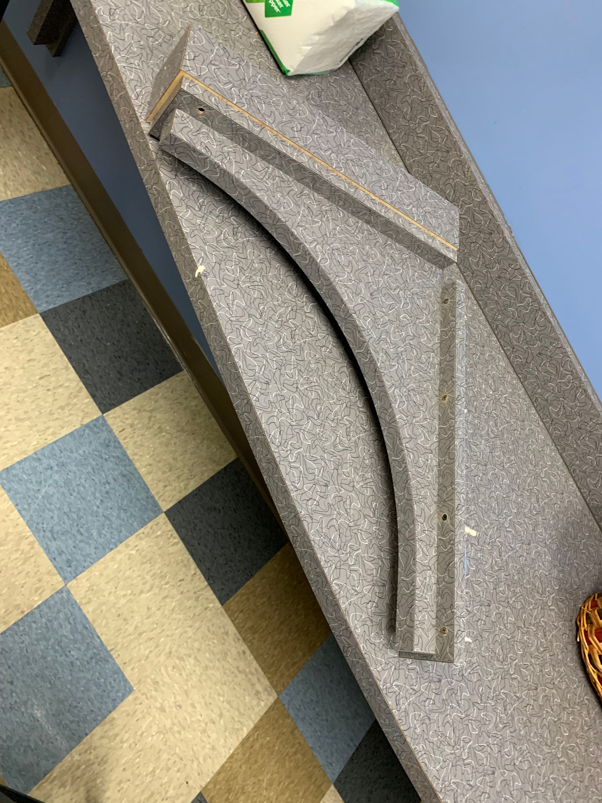 A gray counter top with a checkered floor in the background