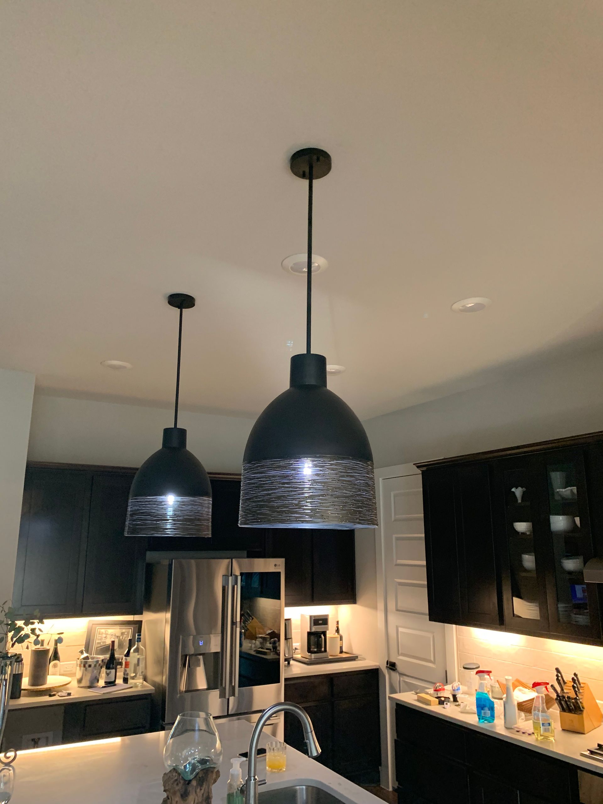 A kitchen with two pendant lights hanging from the ceiling.