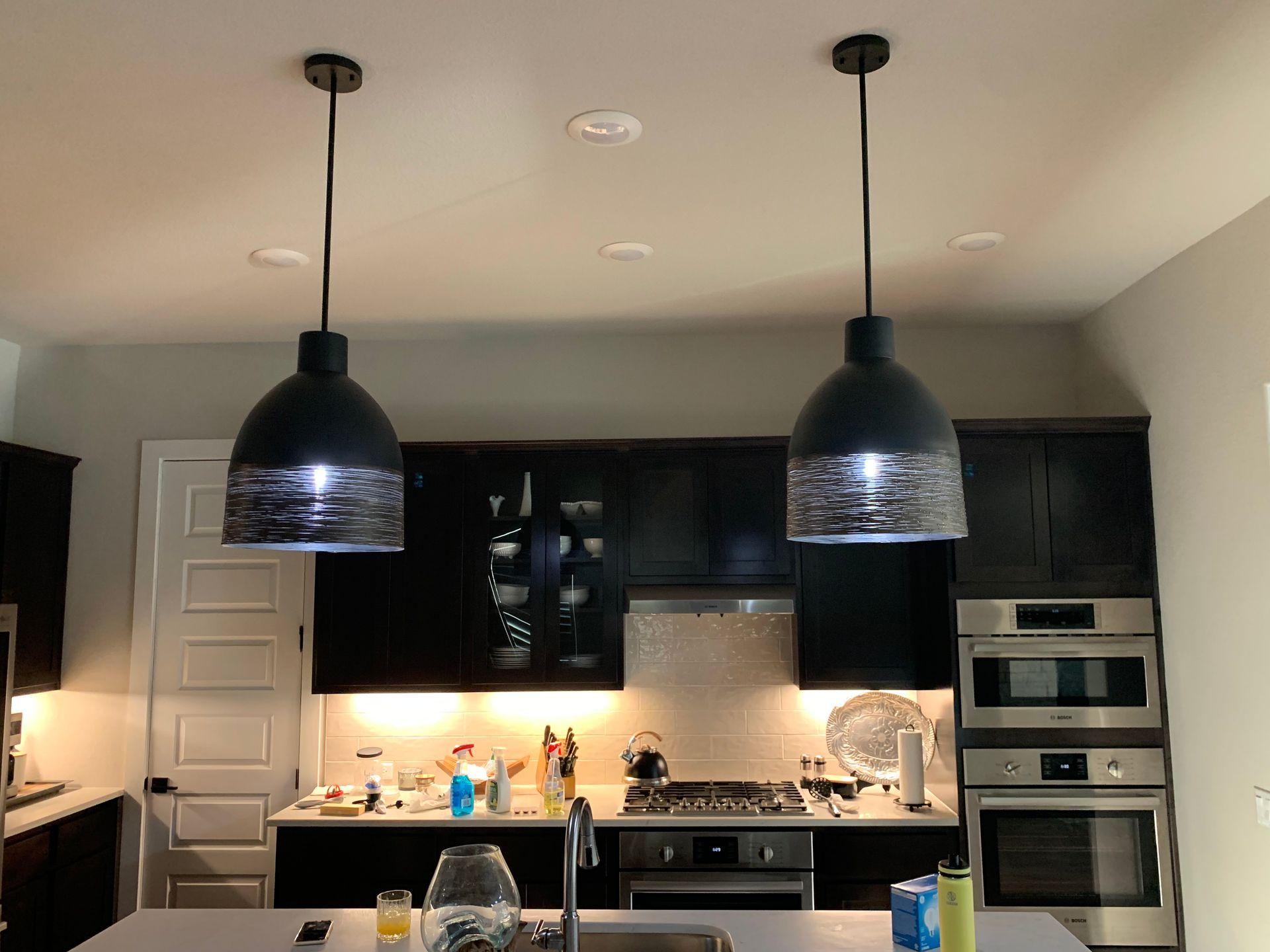 A kitchen with two pendant lights hanging from the ceiling