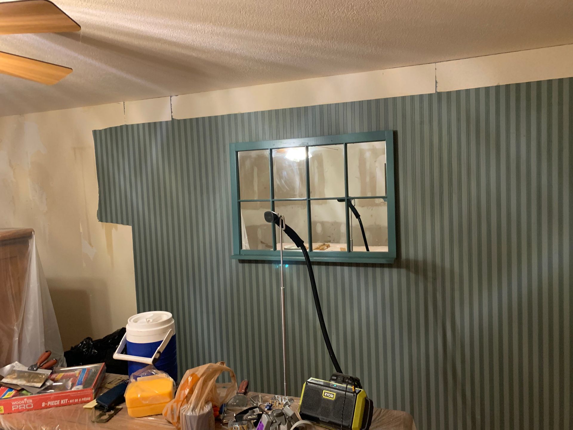 A room with a window and a microphone on the wall.