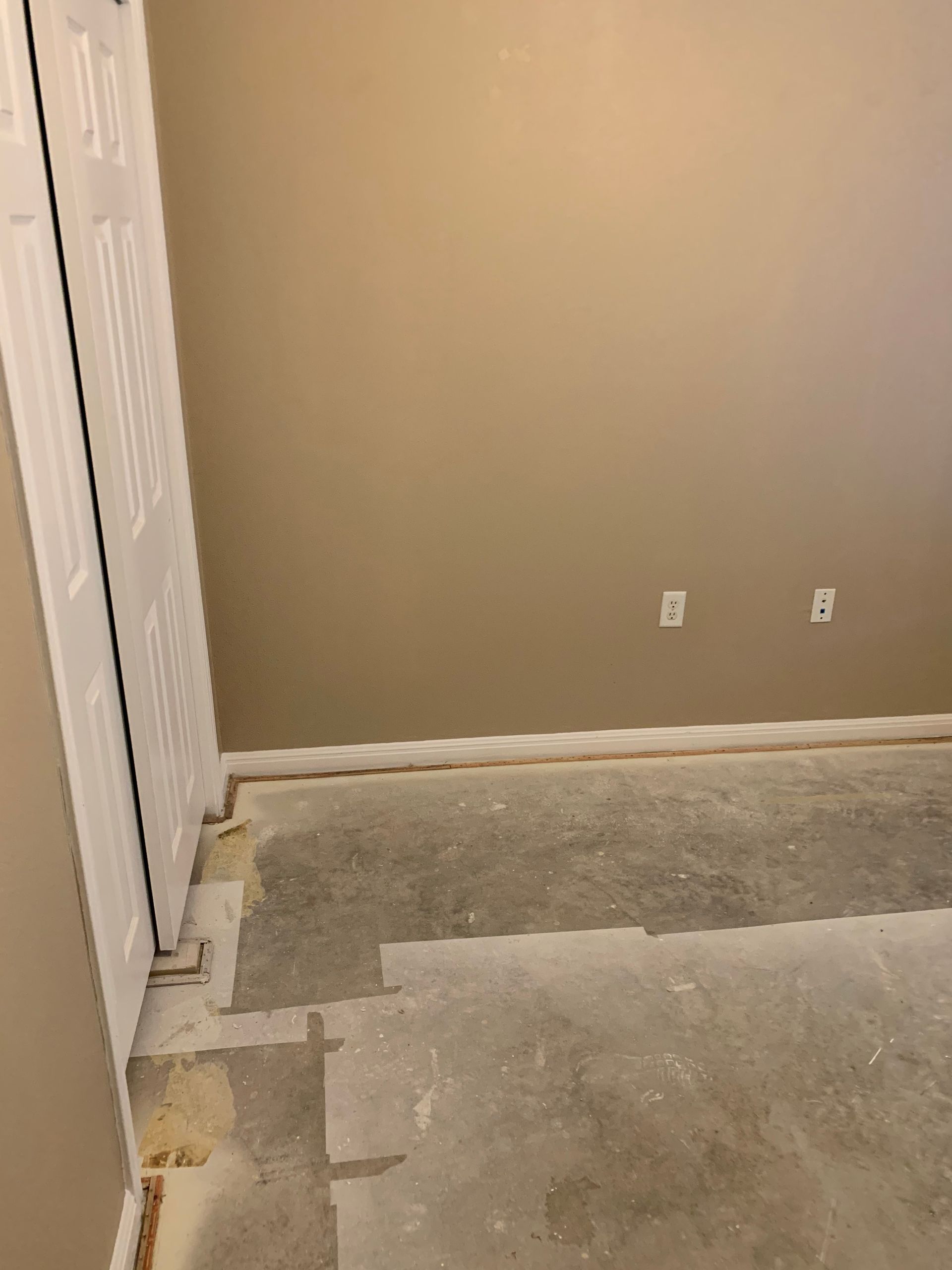 A room with a concrete floor and a door.