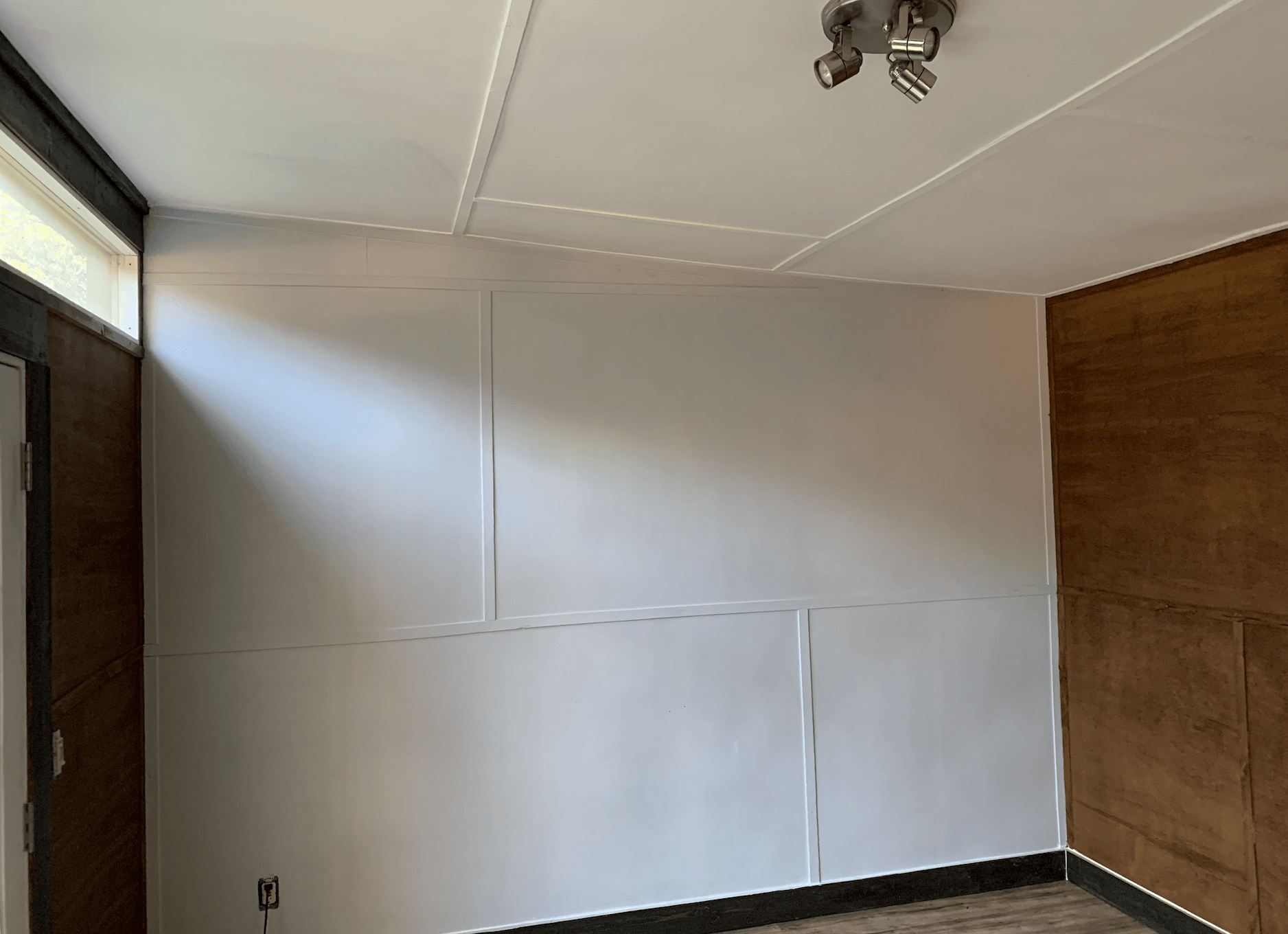 An empty room with white walls and a ceiling light.