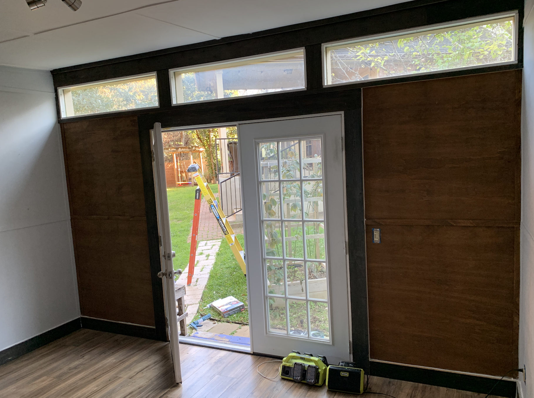 A room with a sliding glass door leading to a backyard.
