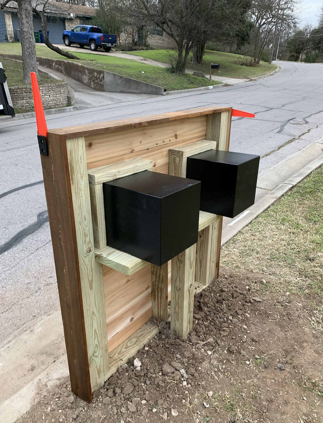 A wooden post with two black boxes attached to it.