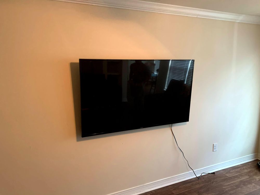 A flat screen tv is mounted on a wall in a living room.
