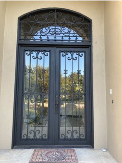 A wrought iron door with a rug in front of it