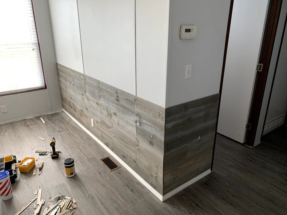 A living room with a wooden wall and a wooden floor.
