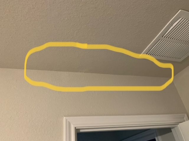 A yellow circle is drawn on the ceiling above a door